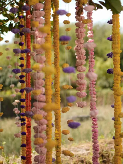 A close-up of the hanging garlands, made from a mix of real flowers and colorful cotton puffs, adding a unique texture.