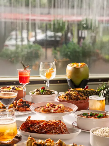 A lavish spread of food and drinks at Gallops, set against a bright window. This image showcases the variety and richness of their menu in a fine-dining context.