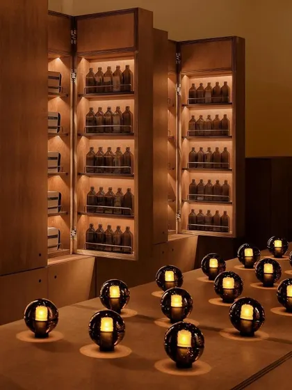 An array of Bocci 14p lamps arranged on a counter in a dark, moody room, creating a striking pattern of light.