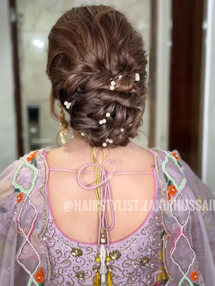 A textured updo with pearl accents scattered throughout. This is a chic and modern way to add a touch of elegance to a classic bun.