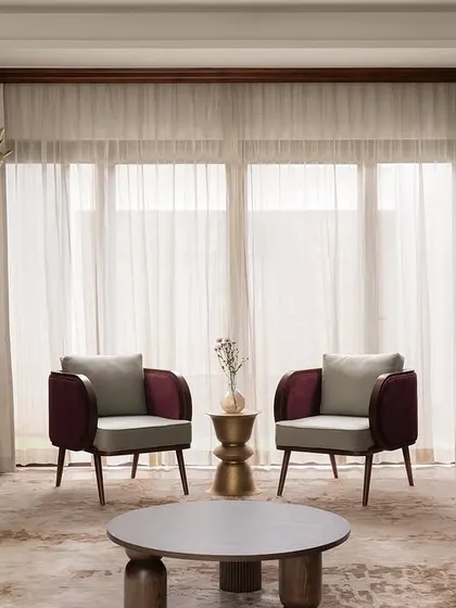 A full view of the formal living room at our Tinted Tapestries project. We paired custom-designed magenta velvet sofas with two-toned armchairs and sculptural brass side tables to create a space that is rich in color, texture, and modern elegance.