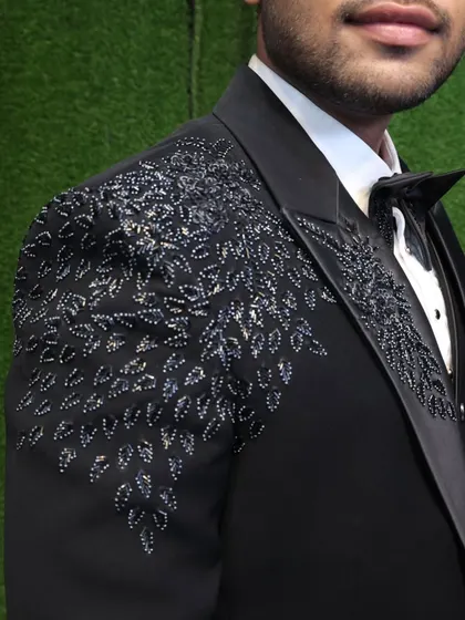 A close-up of the exquisite hand-embroidery on our black party wear tuxedo. The silver and black beadwork creates a stunning leaf pattern on the shoulder.