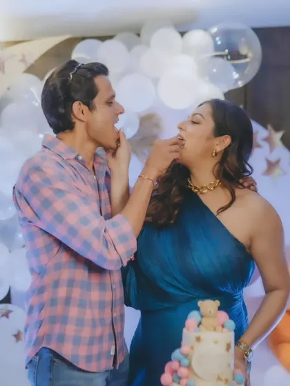 A fun and sweet moment between parents-to-be Drashti Dhami and Neeraj Khemka at their baby shower, enjoying a bite of their custom cake.