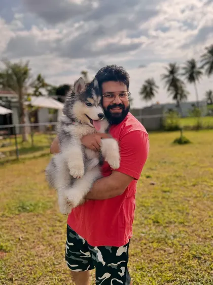 There's nothing like a hug from a big, fluffy puppy. This owner is all smiles with his young Husky.