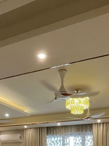 The ceiling design incorporates a metal-clad border around the recessed light cove, adding a sleek and polished finish to the room's fifth wall.