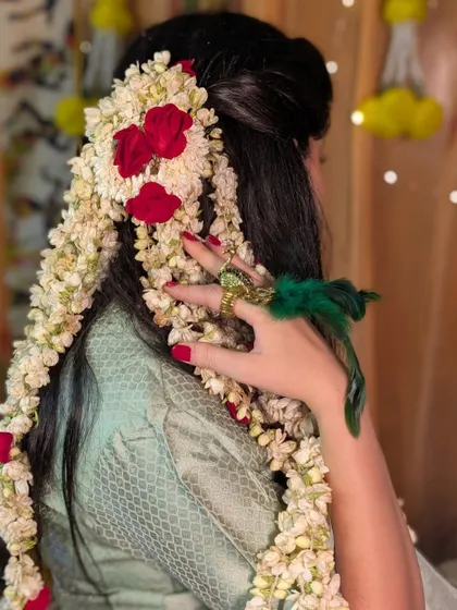 A stunning view of the long, cascading gajra and rose hairstyle created for the Haldi function.
