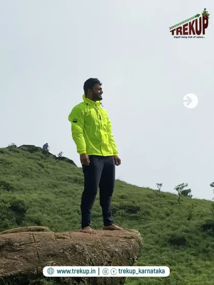 A trekker posing on a rock, looking out at the vast landscape. My treks are full of these epic photo opportunities.