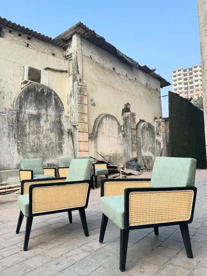 The chairs are shown against an old stone wall, creating a beautiful contrast between the new furniture and the rustic background.