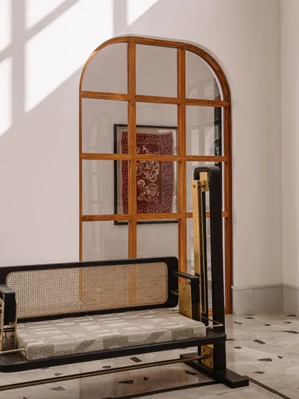 This view highlights the custom-designed swing by Design ni Dukaan, perfectly framed by an arched window and the play of sunlight. It adds a touch of playful elegance to the living space.