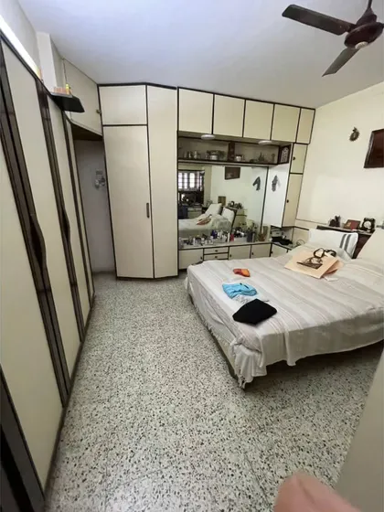 **BEFORE:** The original master bedroom layout, showing how the bulky furniture and terrazzo flooring contributed to a cluttered feel.