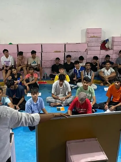 A group of young athletes listens attentively during a classroom session. We are committed to their complete education as martial artists.