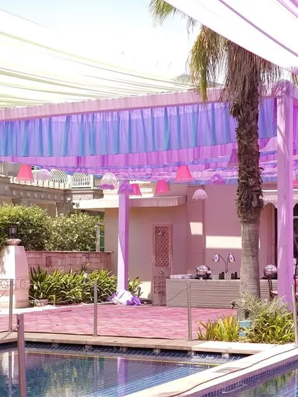 A view of the poolside setup, showing the pastel drapes and the bar area. The entire venue was transformed into a soft, dreamy landscape for the Mehendi celebration.