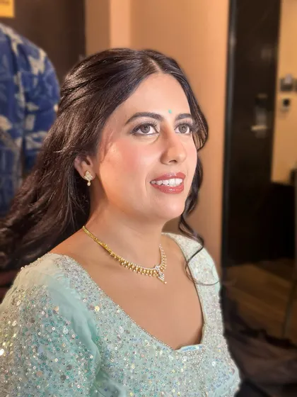 A portrait of modern bridal beauty. The makeup is fresh and radiant, with a focus on glowing skin and softly defined eyes.