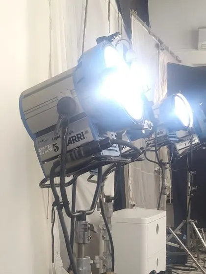 An Arri M40 HMI fixture, a powerful daylight source, is bounced off a large muslin cloth. This technique, known as a book light, creates an extremely soft and flattering quality of light, perfect for commercial and beauty work.