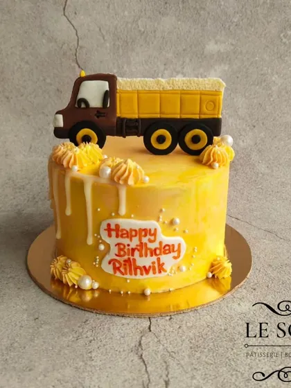 This cake was designed for little Rithvik, who loves trucks. The half-kg Chocolate Truffle cake is topped with a detailed fondant dump truck and has a yellow drip design.