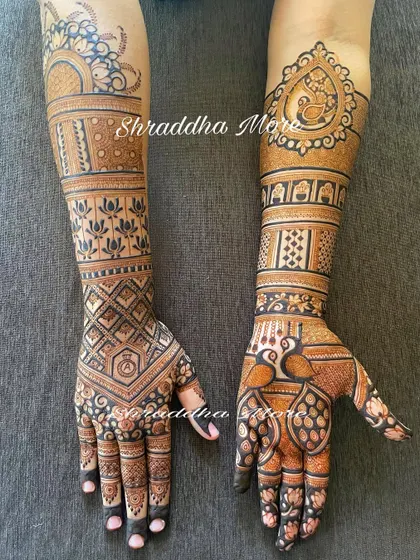 A lovely bridal design with a mix of geometric patterns and traditional motifs. The peacocks and lotuses are beautifully detailed, creating a balanced and elegant look.