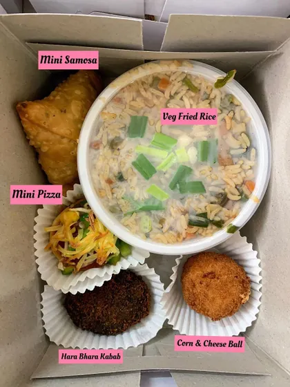 A birthday party snack box with a different combination: Mini Samosa, Veg Fried Rice, Mini Pizza, Hara Bhara Kabab, and a Corn & Cheese Ball.