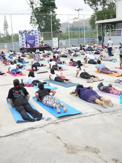Students practicing Salabhasana (Locust Pose) in unison during our outdoor yoga event.