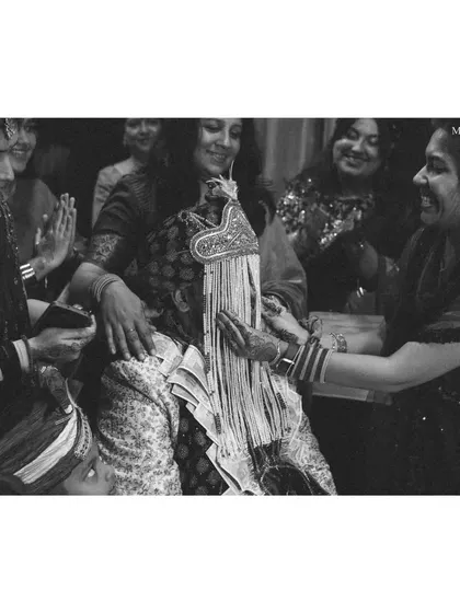 A sweet, candid moment from the groom's welcoming ceremony. This black and white photo captures the smiles and traditions as he is greeted by the bride's family.