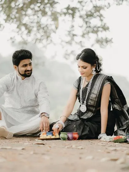 Another angle of the couple preparing for the festival rituals. The focus on their interaction makes the photo feel very personal and real.