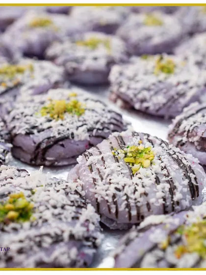 Indulge in our handcrafted Jamun Macaroons. This fusion dessert combines the classic Indian sweet with a French patisserie technique, topped with coconut and pistachio.