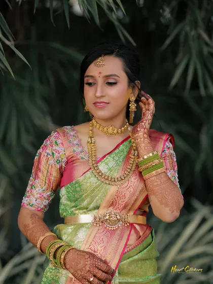 A beautiful bridal portrait taken outdoors, with the bride adjusting her bangles.