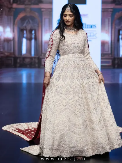 A full view of the showstopper tail gown on the runway, a masterpiece designed for the modern queen with its rich maroon Persian veil.