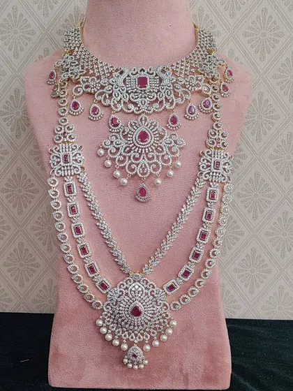 A stunning AD stone bridal set with ruby-colored stones. This gives the magnificent look of a diamond and ruby set, perfect for a grand reception.