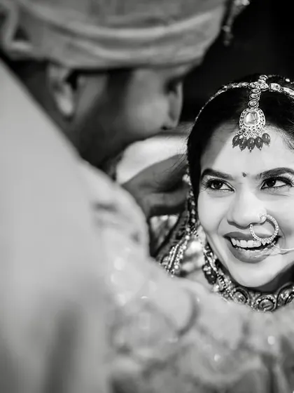 The bride's happy and trusting look as the groom performs a ritual. This black and white close-up is full of emotion.