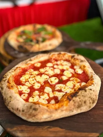A freshly baked Neapolitan margherita pizza, a popular choice from our live pizza station at kids' parties. We use high-quality ingredients to make pizzas that even the adults will love.