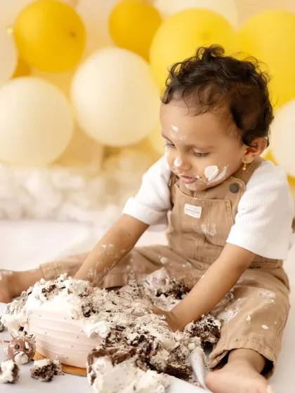 A candid shot of the little one exploring the texture of the cake. Cake smash sessions are a wonderful sensory experience for babies.