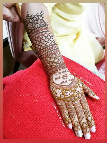 A unique way to include a personal message in the mehndi. This design has the phrase "Main Tulsi tere aangan ki" beautifully written on the palm, surrounded by intricate patterns.