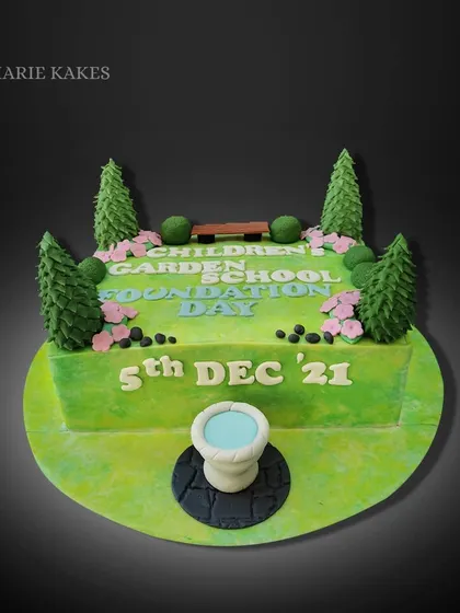 A garden-themed chocolate truffle cake for a school's foundation day. I created a little park scene with fondant trees, a bench, and a small fountain.