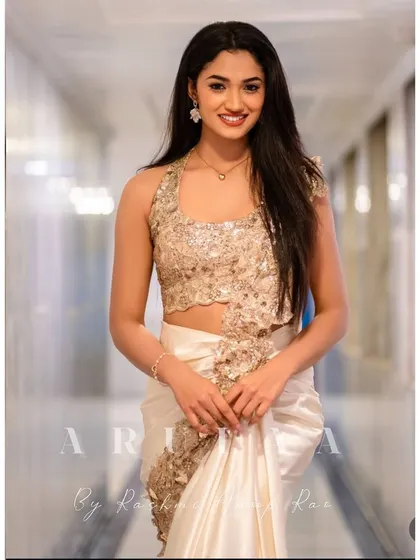 A smiling shot of Reeshma in the ivory and gold concept saree. The embellished halter blouse is the star of this outfit, providing a modern and chic alternative to a traditional saree blouse.