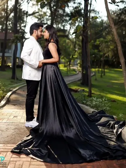 A romantic pre-wedding shoot in a park. This couple looks elegant in our black satin flying gown and a matching white blazer.