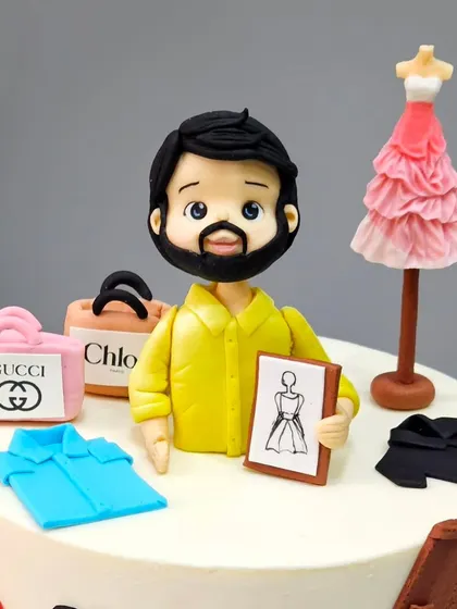 A close-up of the fashion stylist figurine, holding a sketch board. We included miniature shopping bags from luxury brands like Gucci, Chloe, and Dior to capture his world perfectly.