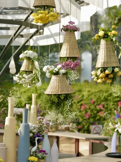 Whimsical hanging baskets overflowing with flowers, a creative and beautiful way to decorate a bar or food station.