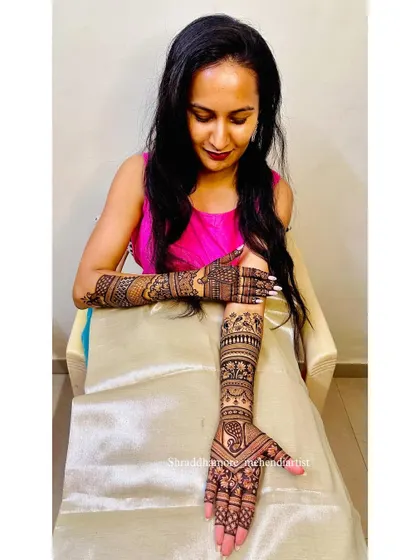 A lovely photo of a bride showing her full mehendi, with a beautiful smile.