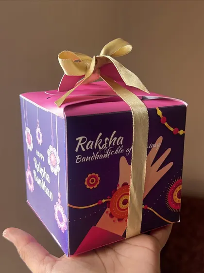 A custom-printed Rakhi gift box held in hand, showing a beautiful and convenient gifting option.