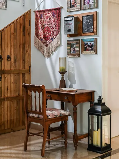 A quaint corner next to the staircase with a retro-style writing desk, a mock postbox, and a large candle lantern, creating a romantic, vintage feel.