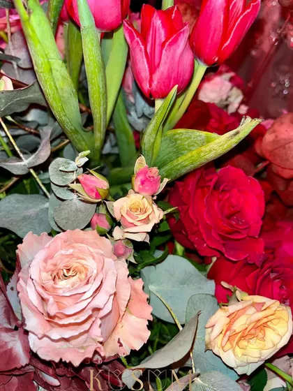 A close-up on love. This Valentine's arrangement features a mix of red tulips and different shades of pink roses, a classic and beautiful expression of romance.