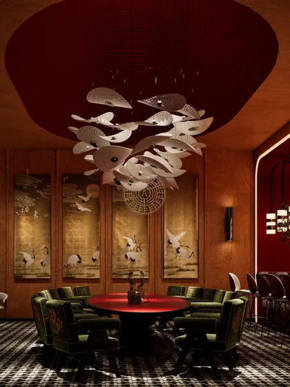 The Koko suite offers an exclusive dining experience, with a custom red table, luxurious embroidered green chairs, and a unique fish-motif chandelier, all set against traditional hand-painted panels.
