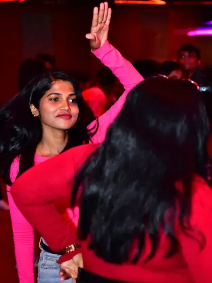Two friends dancing and enjoying the music at the Anirudh fan party. It's all about creating a fun and safe space for everyone.