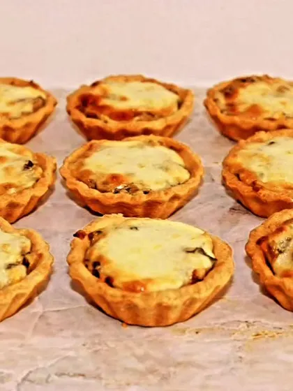 A tray of our savory mushroom tarts, fresh out of the oven. The buttery crust and creamy filling make them a delicious and elegant appetizer.