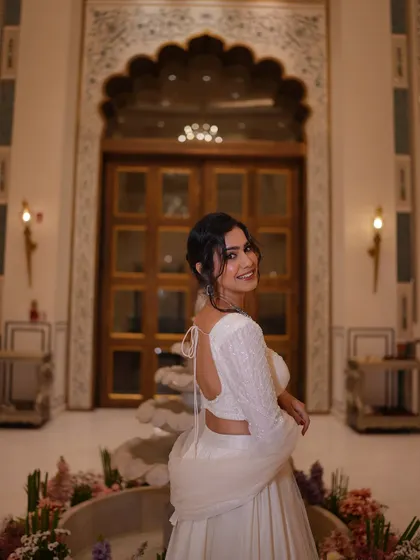 A beautiful back shot of the white lehenga, highlighting the blouse design and the elegant updo.