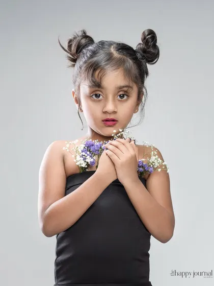 A modern and artistic portrait of a girl with flowers adorning her. The simple background and creative styling make this a unique shot.