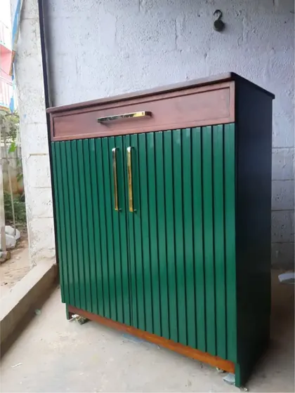 The green bar cabinet during its finishing stages at our workshop, showing the rich color and sleek brass handles.
