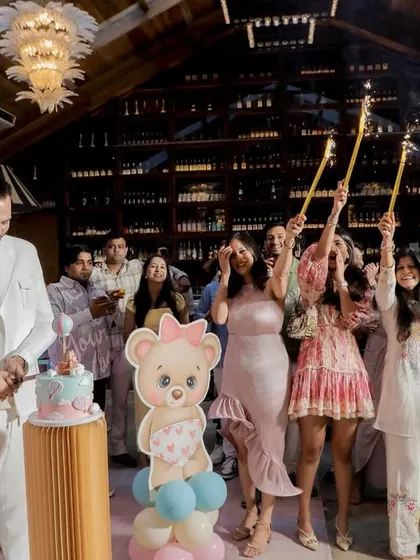 Another angle of the magical cake cutting, surrounded by teddy bear decor and a pastel balloon arch.