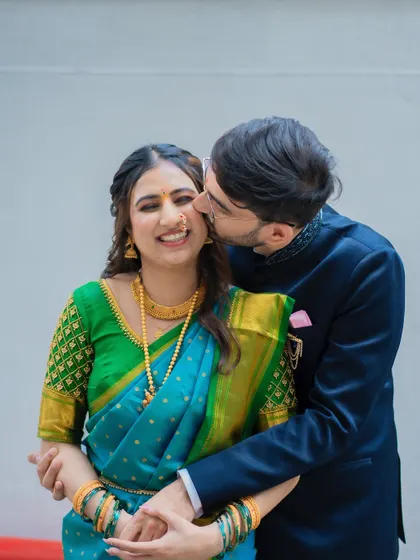 A playful and affectionate kiss on the cheek. This candid shot is full of joy and captures the pure happiness of their engagement day.
