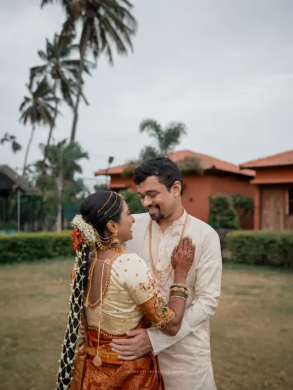 A sweet moment between the couple, set against a backdrop of palm trees, showcasing a beautiful resort wedding feel.